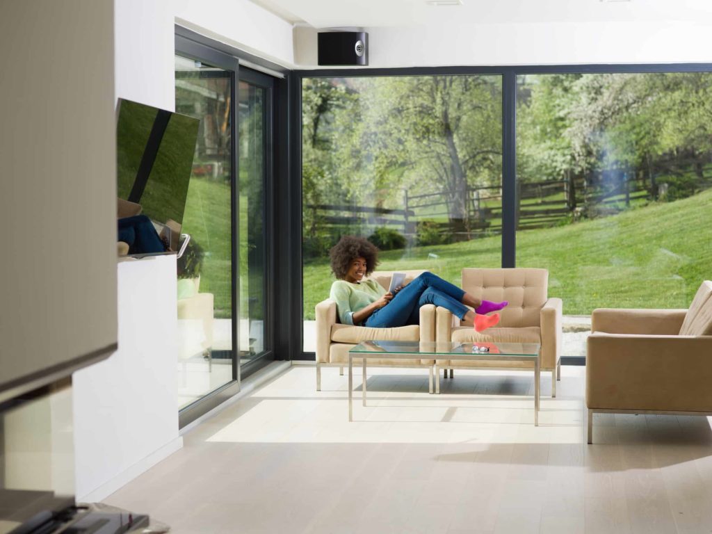 woman on a sofa in front of doors by C&A Window Systems Partners